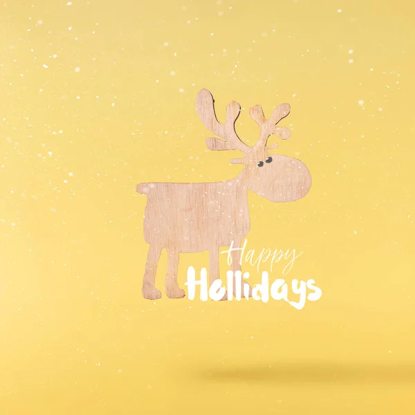 クリスマスのコンセプトです 創造的なクリスマス概念落ちることによって作られた黄色の背景の上のクリスマス木製鹿の空気します 最小限のコンセプト — ストック写真