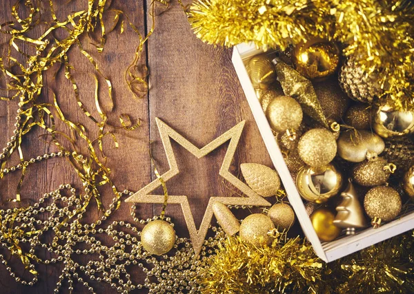 クリスマスの背景 たくさんの異なるゴールド安物の宝石 暗い木製のボード上の装飾 クリスマス準備コンセプト — ストック写真