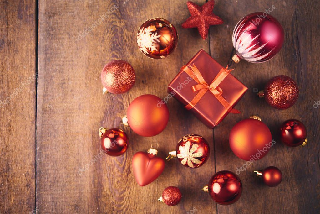 Christmas background. A lot of red vintage baubles, gift box and fir tree over dark wooden board. Christmas concept
