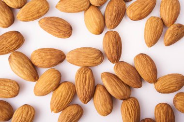 Bir sürü beyaz arka plan üzerinde izole taze çiğ badem. Organik sağlıklı vegan snack.