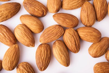 Bir sürü beyaz arka plan üzerinde izole taze çiğ badem. Organik sağlıklı vegan snack.