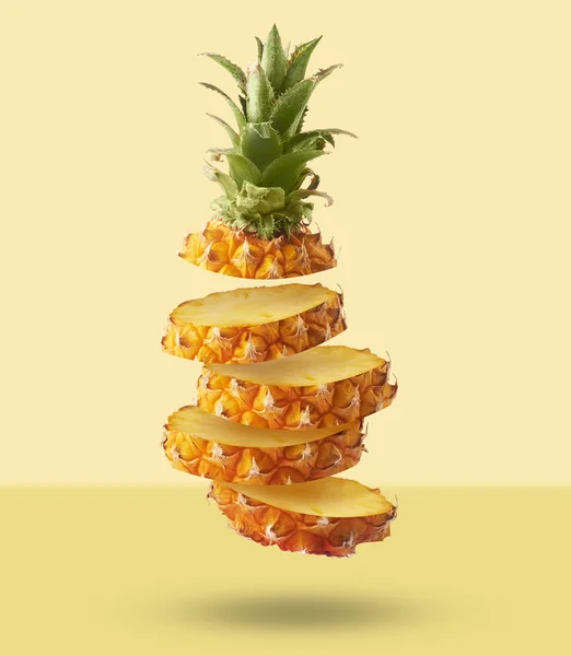 Vliegen in de lucht vers rijp hele en gesneden baby ananas met segment — Stockfoto