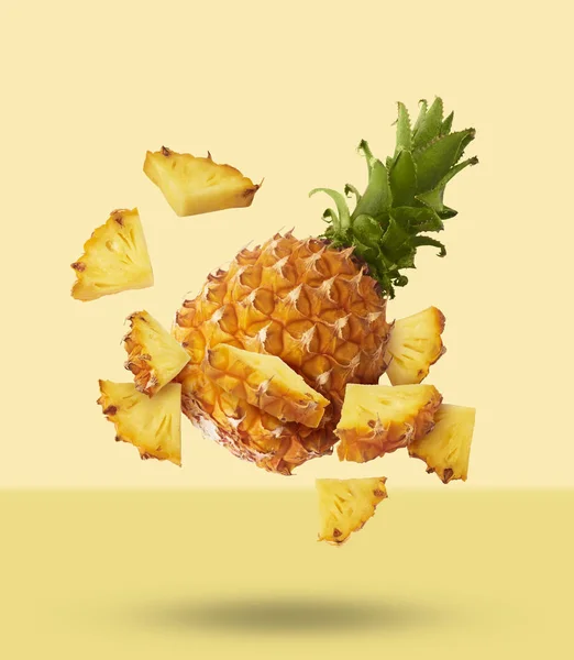 Vliegen in de lucht vers rijp hele en gesneden baby ananas met segment — Stockfoto