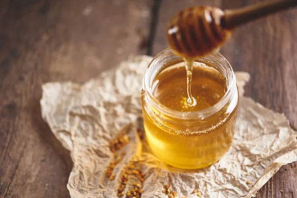 Dulce Hohey fresco en tarro de vidrio con cazo de madera — Foto de Stock