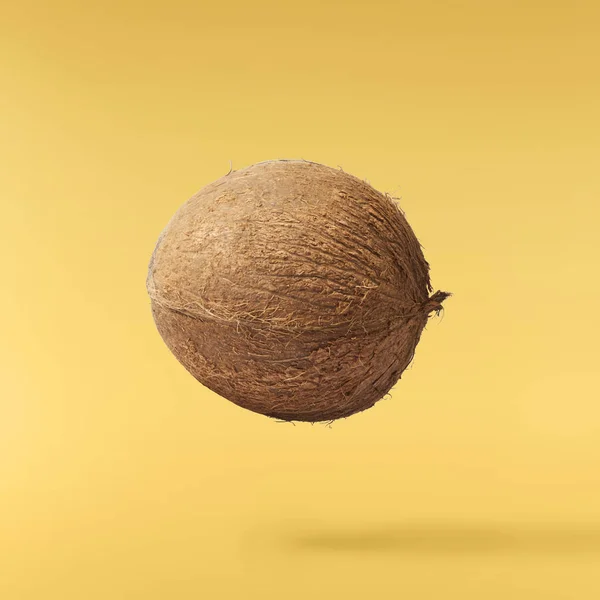 Čerstvý zralý kokosový ořech izolovaný na žlutém pozadí — Stock fotografie