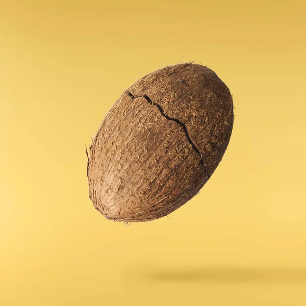 Čerstvý zralý kokosový ořech izolovaný na žlutém pozadí — Stock fotografie