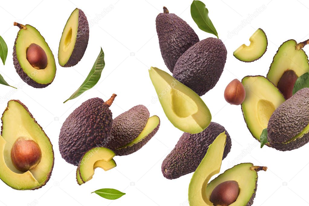 Fresh ripe avocado with leaves falling in the air. 
