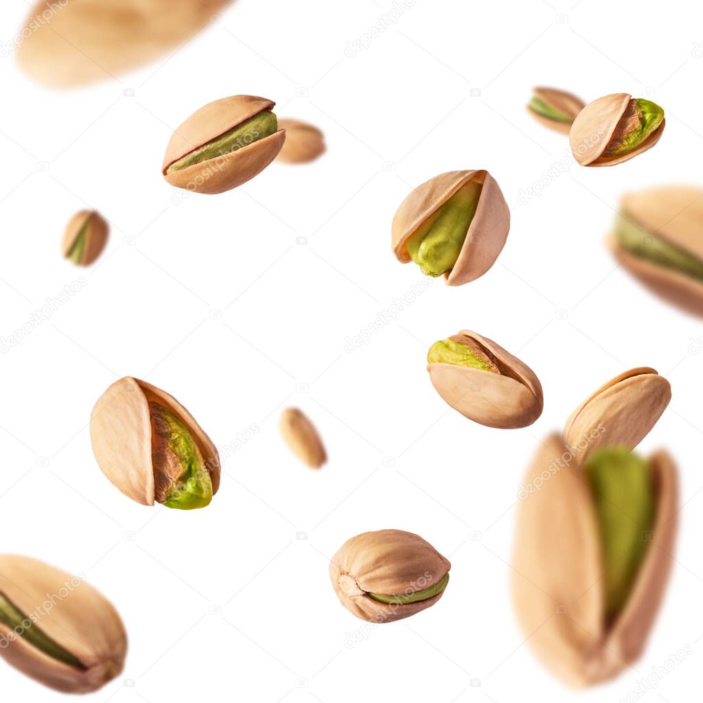 Flying in air fresh raw whole and cracked pistachios  isolated on white background. High resolution image