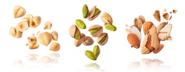 A set with Flying in air fresh raw whole and cracked pistachios, almonds and hazelnut isolated on white background. Concept of Pistachios almonds and hazelnut is torn to pieces close-up. High resolution image clipart