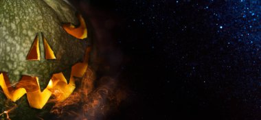 Cadılar Bayramı geçmişi. Karanlıkta ürkütücü balkabağı parlıyor. Copyspace ile Cadılar Bayramı tasarımı