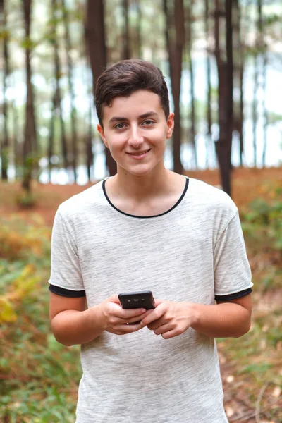Felice Adolescente Utilizzando Telefono Cellulare Nella Foresta — Foto Stock