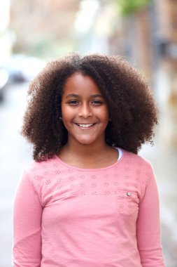 Sokağın ortasında gülümseyen sevimli Afro-Amerikan kız