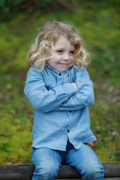 Wütender Kleiner Junge Mit Langen Blonden Haaren Sitzt Draußen Mit — Stockfoto