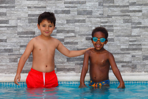 cute happy little boys having fun in pool 
