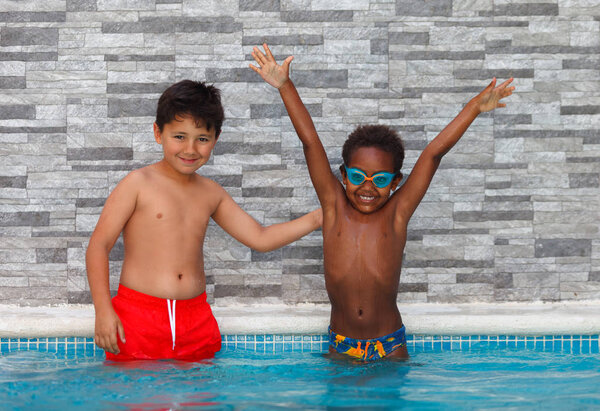 cute happy little boys having fun in pool 