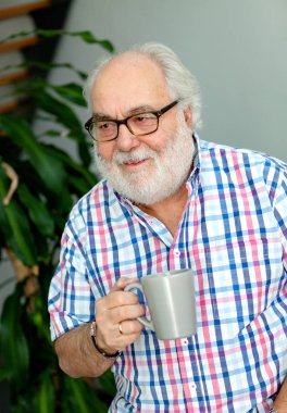 evde rahatlatıcı ve kahve içme beyaz sakallı üst düzey adam portresi 