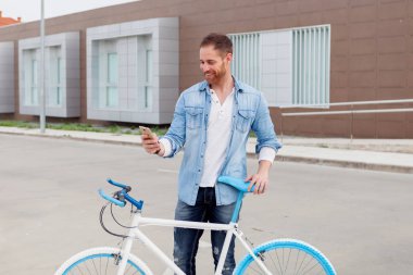 cep telefonu kullaranarak Bisiklet ile yakışıklı genç adam