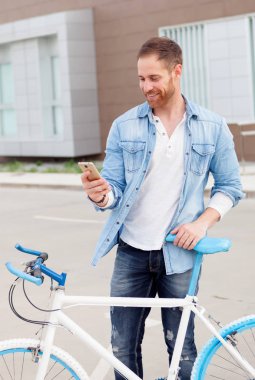 cep telefonu kullaranarak Bisiklet ile yakışıklı genç adam