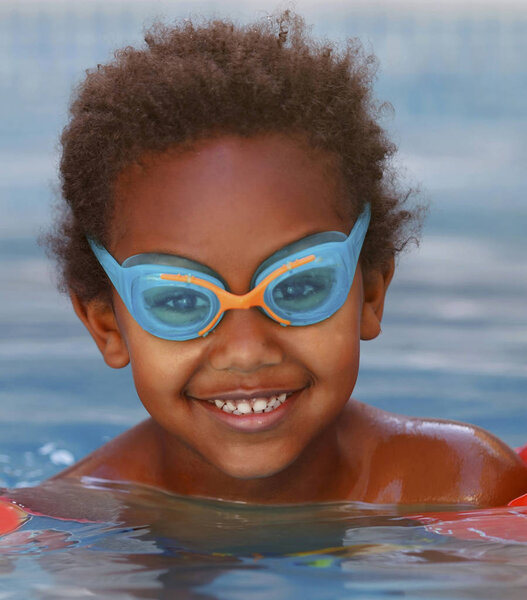 cute happy Afro-American kid with goggles in the pool 