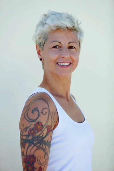 Blondi Nainen Kukkivat Tatuoinnit Käsivarteensa — kuvapankkivalokuva