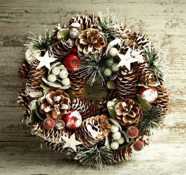 Çam kozalakları gri ahşap arka plan üzerinde hassas Noel çelenk