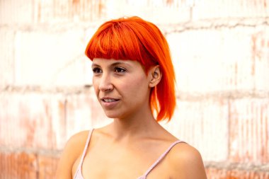 Pembe tişört ve turuncu saçlı komik genç kadın