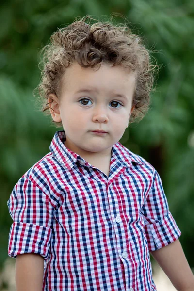 庭の格子縞のシャツと美しい赤ちゃん — ストック写真