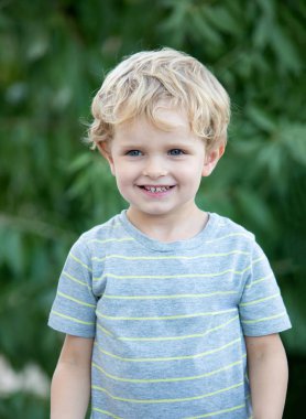 Bahçede oynarken mavi t-shirt ile mutlu çocuk 