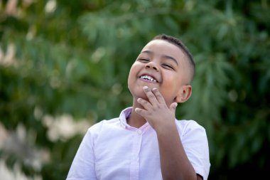 Bir parkta beyaz gömlek ile Pensive küçük çocuk