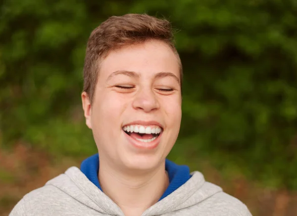 Gelukkige Tiener Kerel Lacht Met Een Natuurlijke Achtergrond — Stockfoto
