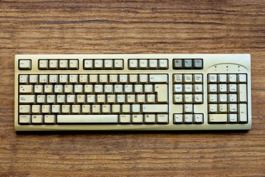 Ahşap arka plandaki bilgisayarın eski klavyesi