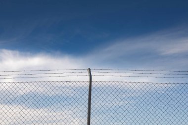 Tel örgü. Mavi gökyüzü bulutlu.