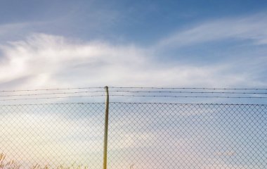 Tel örgü. Mavi gökyüzü bulutlu.