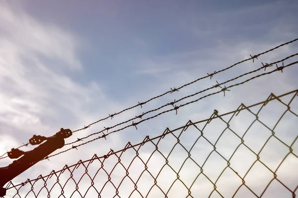 Wire fence with a blue sky with clouds — Stock Photo, Image