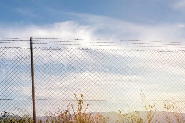 Wire fence with a blue sky with clouds — Stock Photo, Image