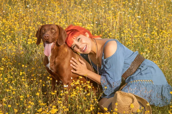 Happy woman in the countryside with her dog enjoying the nature