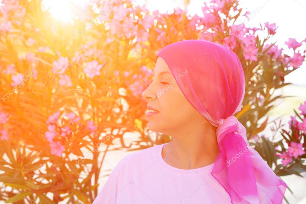 Woman with pink scarf on the head. Cancer awareness