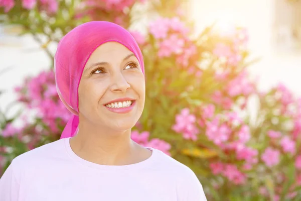 Mulher com cachecol rosa na cabeça — Fotografia de Stock