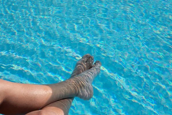 Alguém com os pés na piscina — Fotografia de Stock