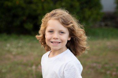 Bir parkta uzun saçlı komik sarışın çocuk