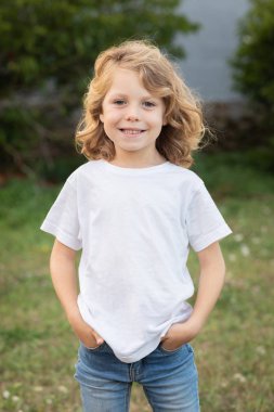 Bir parkta uzun saçlı komik sarışın çocuk