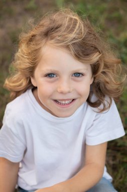 Bir parkta uzun saçlı komik sarışın çocuk