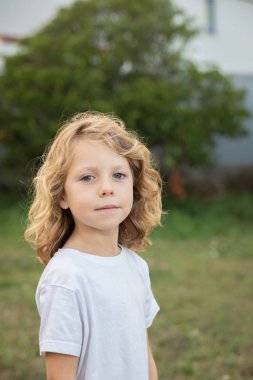 Bir parkta uzun saçlı komik sarışın çocuk