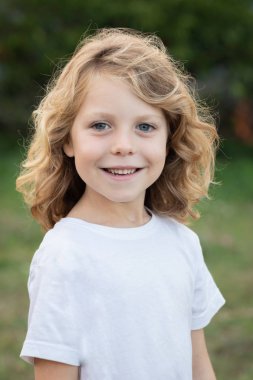 Bir parkta uzun saçlı komik sarışın çocuk