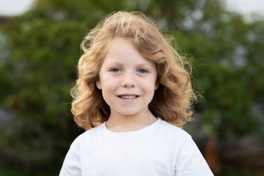 Bir parkta uzun saçlı komik sarışın çocuk