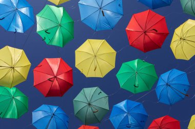 Sokak için gölge vermek için gökyüzünde renkli şemsiyeler