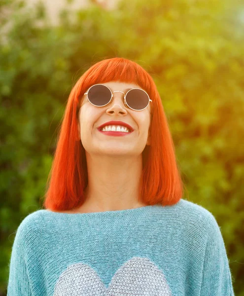 Roodharige vrouw op zoek naar omhoog in een park — Stockfoto