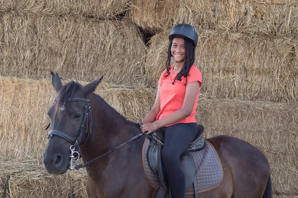 Beautiful teenager with his horse learning to ride