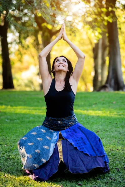Brünette Frau macht Yoga in einem Park — Stockfoto