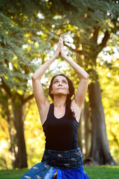 Esmer kadın parkta yoga yapıyor. — Stok fotoğraf